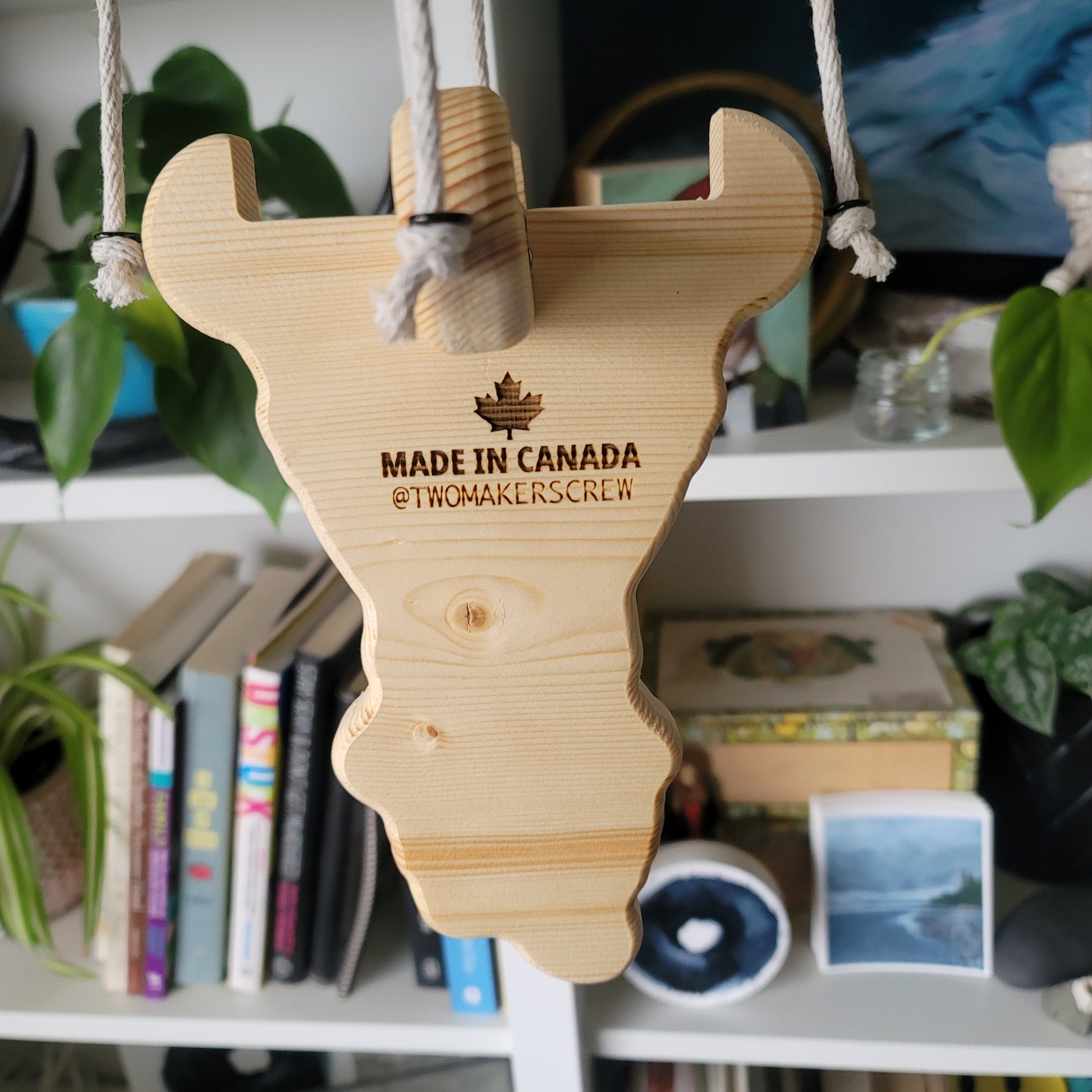 Wooden guitar-shaped tool with 'Made in Canada' text on a blurred background