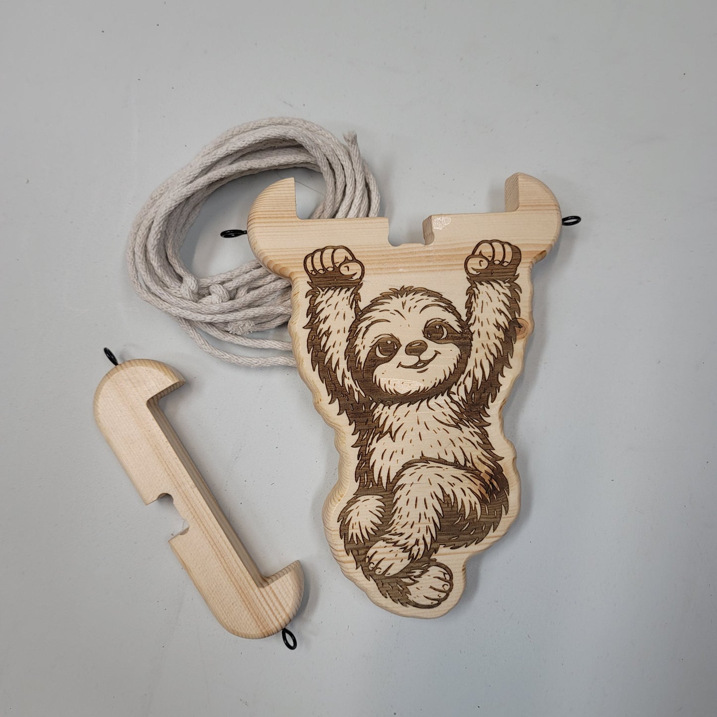Wooden sloth plant hanger  with a rope on a light gray background