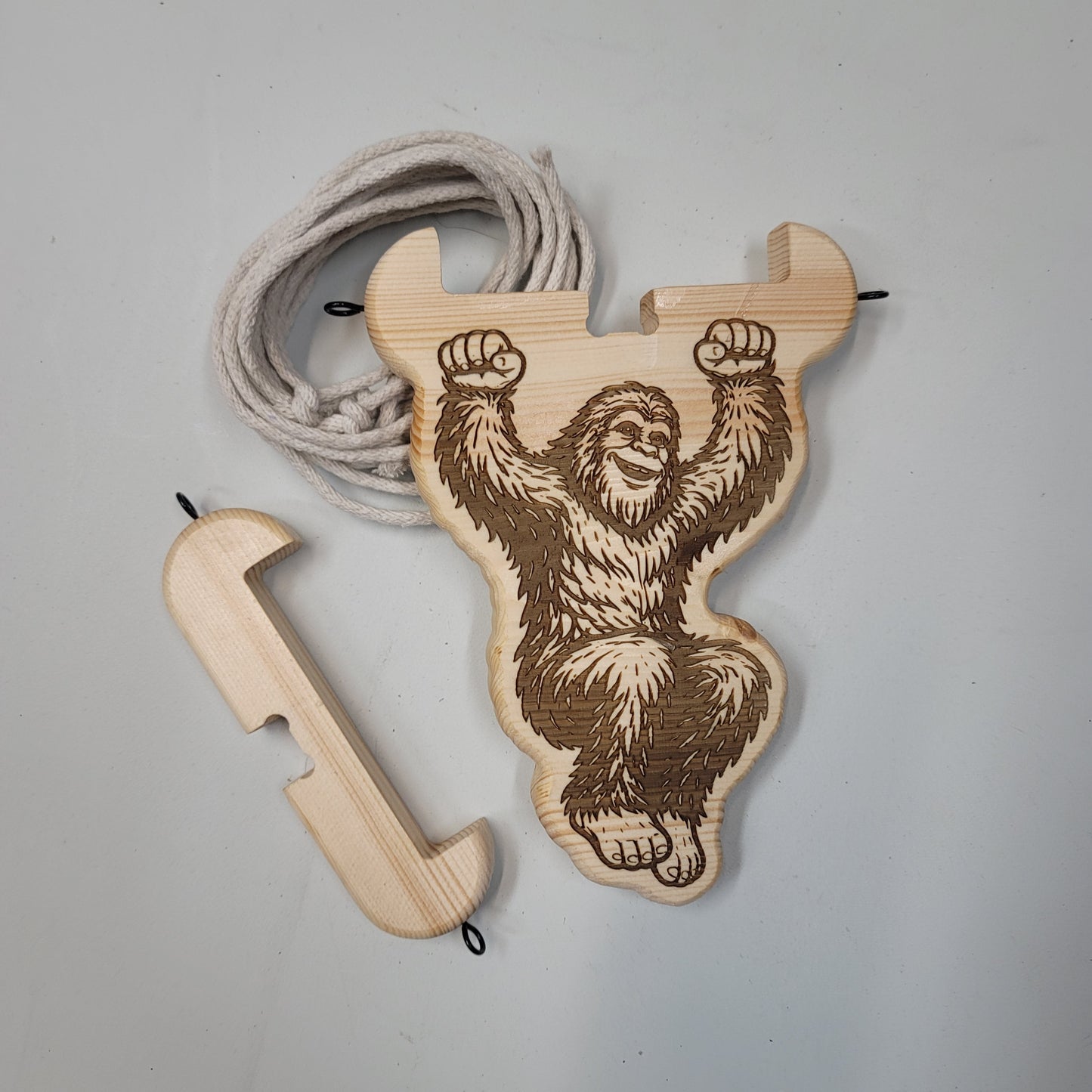 Wooden bigfoot with rope on a gray background