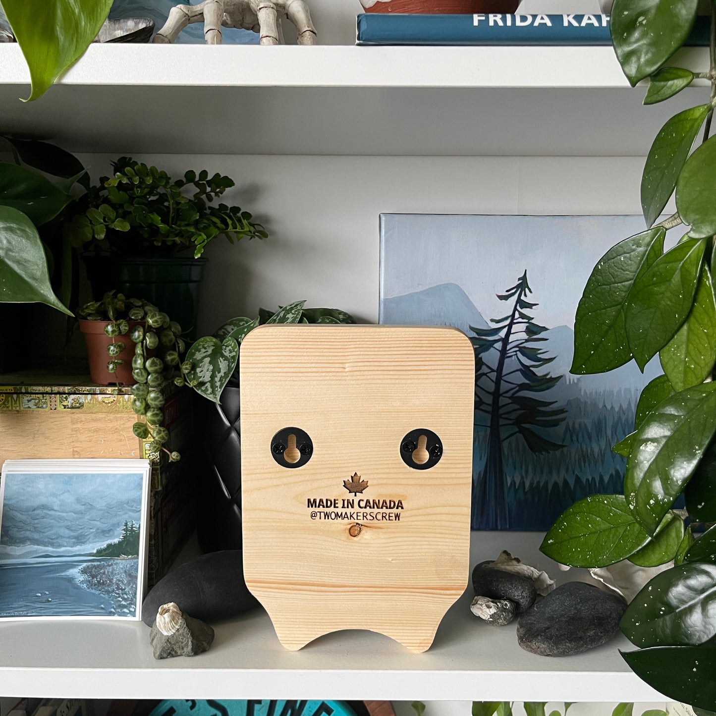 Wooden product with 'Made in Canada' label on a shelf with plants and decor